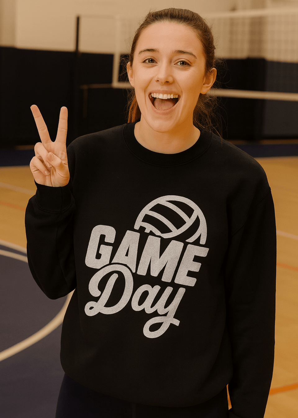 Person wearing a black 'Game Day' sweatshirt with a volleyball graphic on a basketball court.